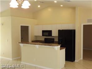 669 Homestead Road South, Unit 71 Lehigh Acres, FL 33974 - Photo 10 of 21 a kitchen with a refrigerator and a stove