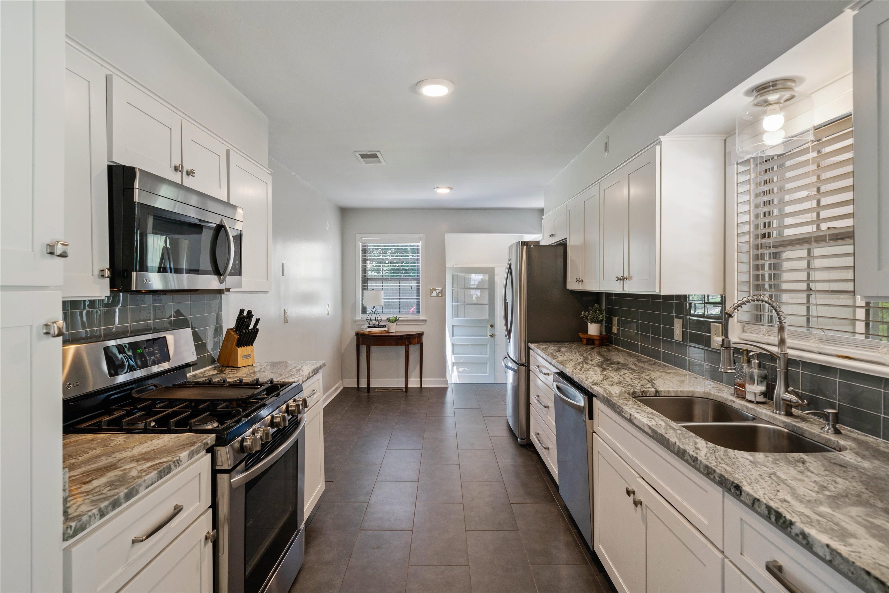 4208 Chickasaw Road Memphis, TN 38117 - Photo 8 of 25 a kitchen with stainless steel appliances granite countertop a sink stove microwave and refrigerator