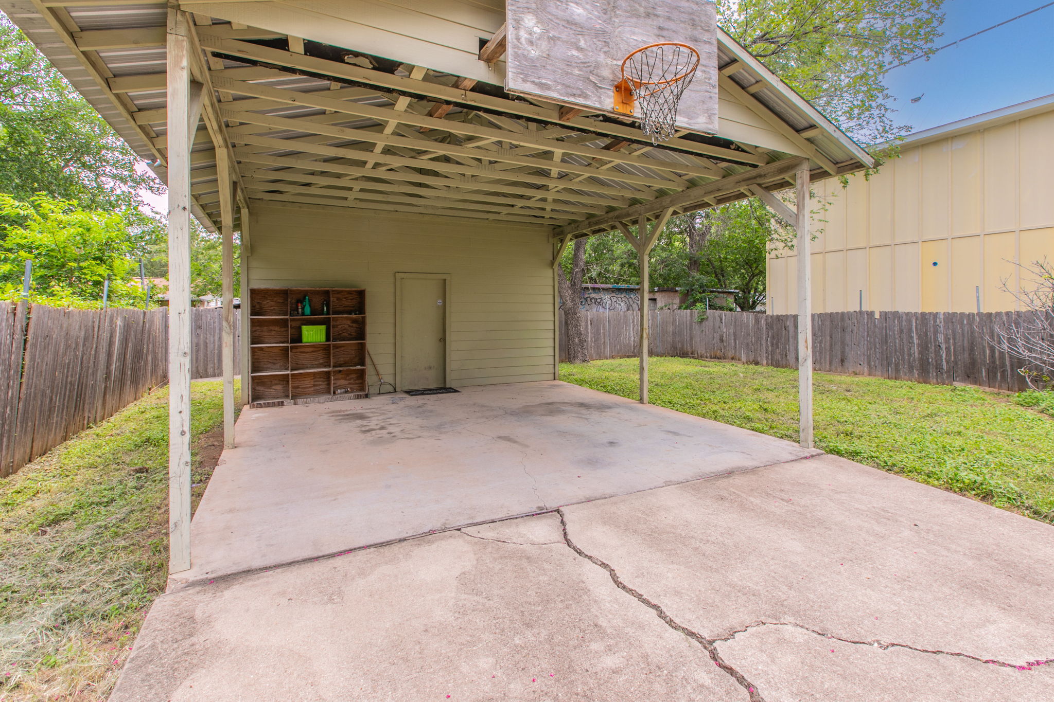 1107 Vargas Road Austin, TX 78741 - Photo 14 of 17 A versatile carport with a built-in basketball hoop offers both shelter and recreation.