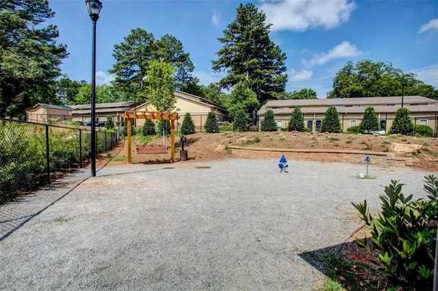 a white house with a large tree with wooden fence