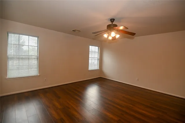 a view of wooden floor and windows in an empty room