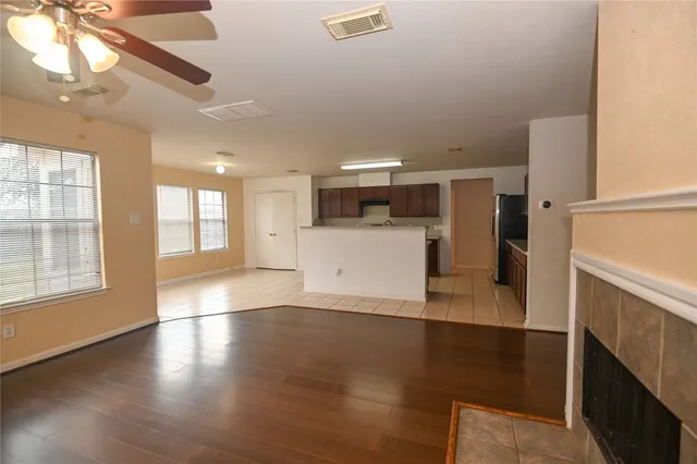 an empty room with wooden floor and windows