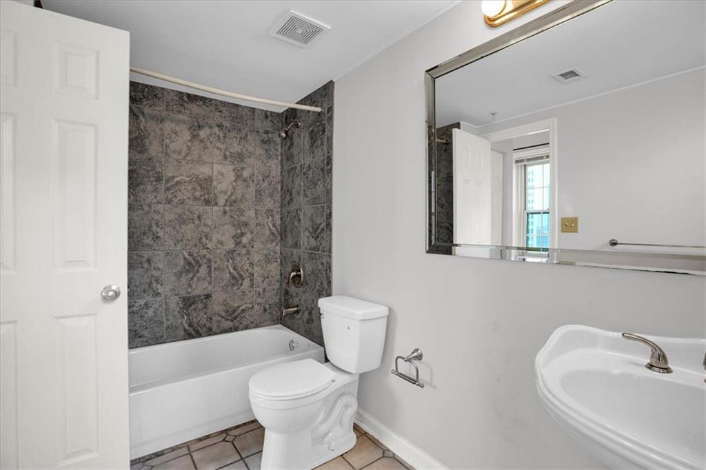 199 14th Street Northeast, Unit 2308 Atlanta, GA 30309 - Photo 22 of 35 a bathroom with a bathtub shower sink mirror and toilet