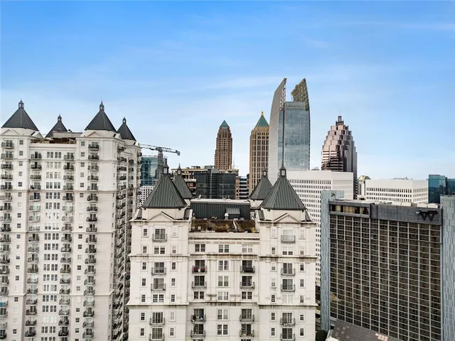 a dining hall with stainless steel appliances a dining table and chairs with the granite countertops