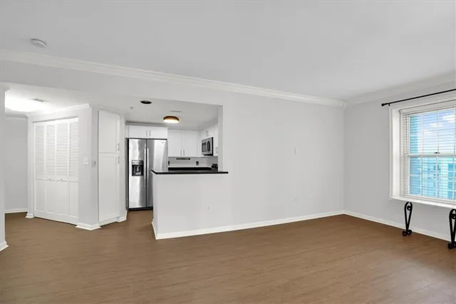 a kitchen with stainless steel appliances granite countertop a sink a refrigerator a microwave a stove and white cabinets