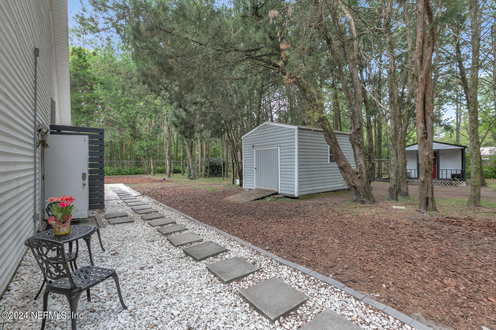 6695 Highway 16 St. Augustine, FL 32092 - Photo 32 of 46 a view of a backyard with white furniture and large tree