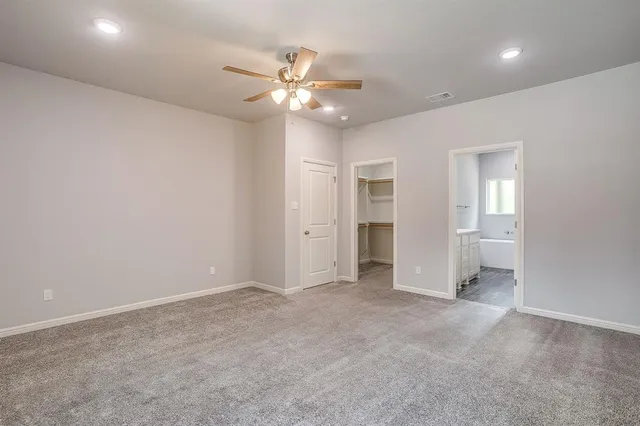 an empty room with closet and fan