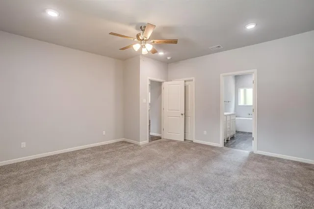 an empty room with closet and fan
