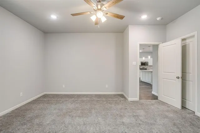 an empty room with a bathroom and a ceiling fan