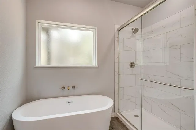 a white bath tub sitting next to a shower