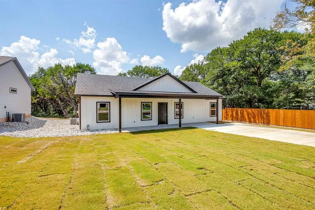 a front view of a house with swimming pool and trees