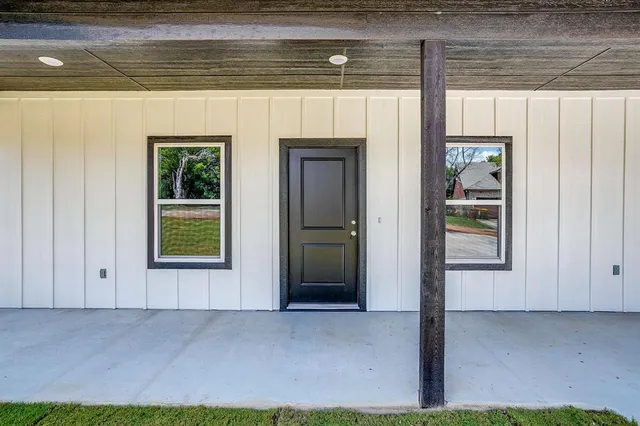 a view of an empty room with a fireplace and a window