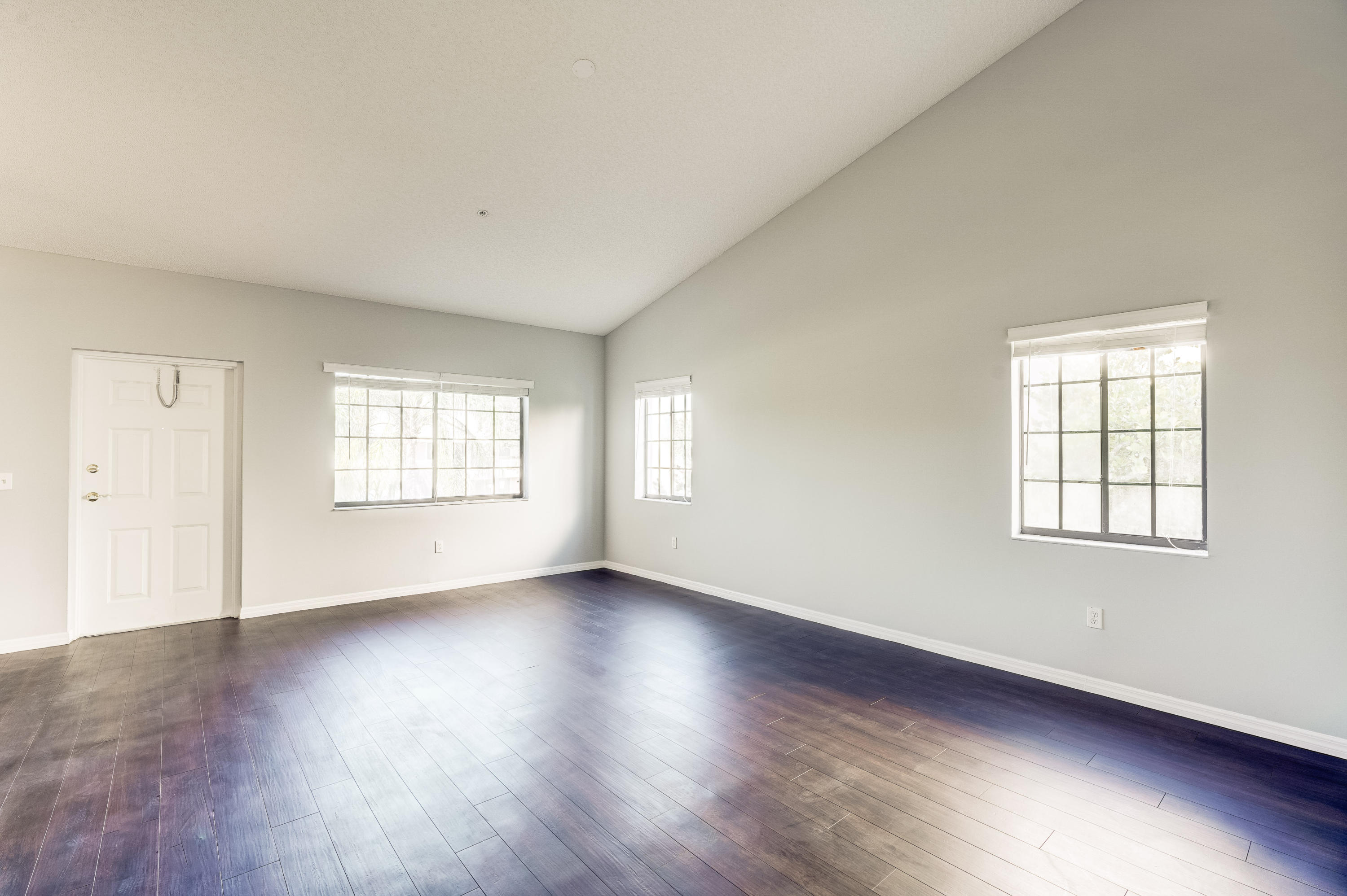 4685 Haverhill Road, Unit F4 West Palm Beach, FL 33417 - Photo 5 of 34 an empty room with wooden floor and windows