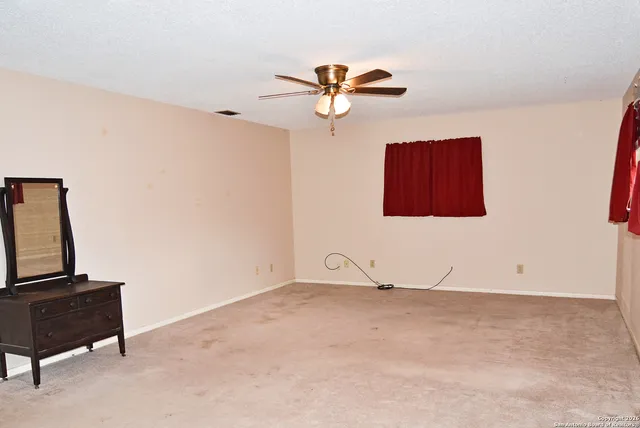 a view of a room with wooden floor and ceiling fan