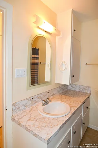 a bathroom with a granite countertop sink and a mirror