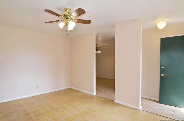 an empty room with closet and a chandelier fan
