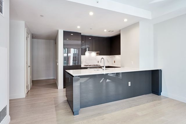 a view of kitchen with stainless steel appliances granite countertop a refrigerator and a sink