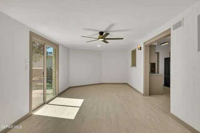 an empty room with fan and windows