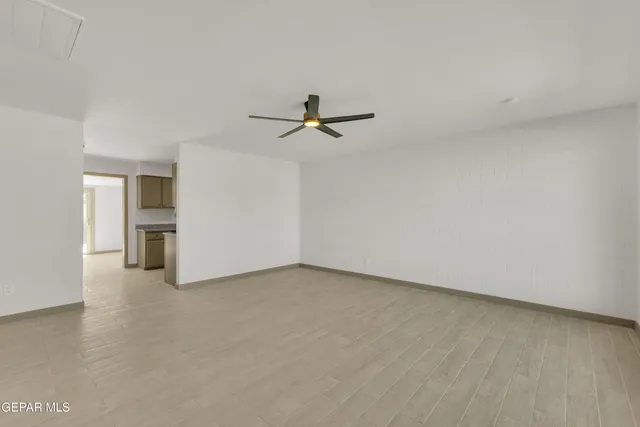 wooden floor in an empty room with a ceiling fan