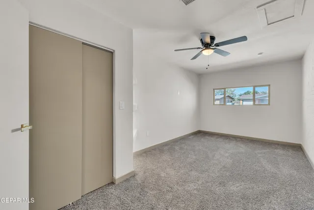 a view of an empty room and window ceiling fan