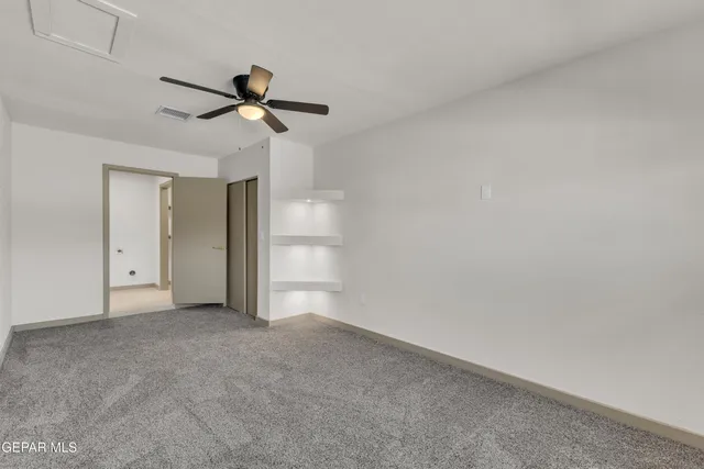 a view of empty room with ceiling fan