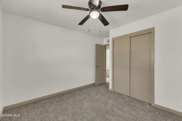 an empty room with chandelier fan