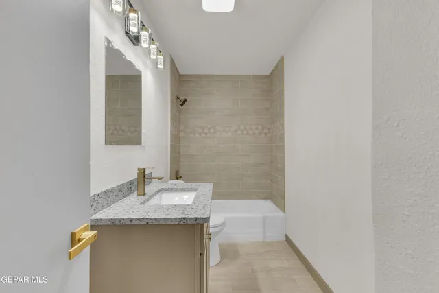 a bathroom with a granite countertop sink and a mirror