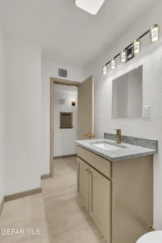 a bathroom with a granite countertop sink and a mirror