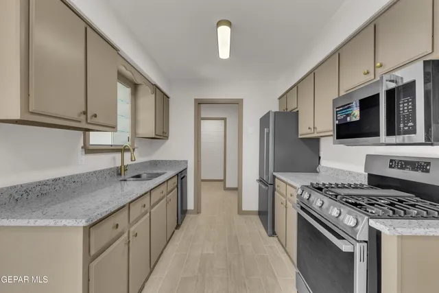 a kitchen with stainless steel appliances granite countertop a sink stove and refrigerator