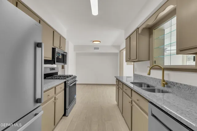a kitchen with stainless steel appliances granite countertop a sink stove and cabinets