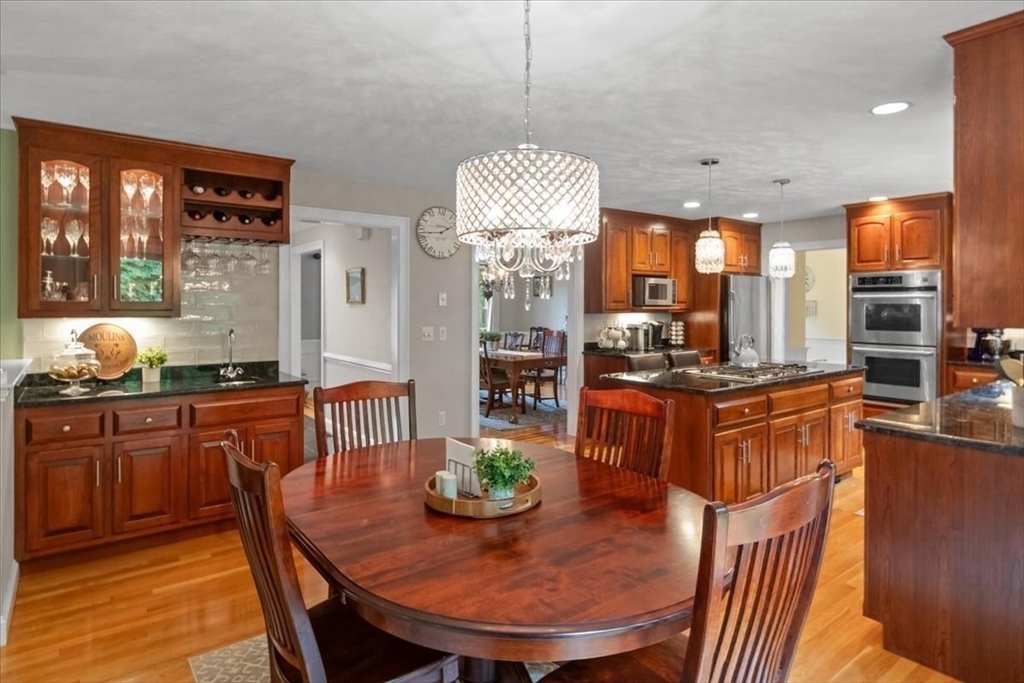 22 Dover Drive Walpole, MA 02081 - Photo 10 of 41 a kitchen with stainless steel appliances granite countertop a stove a kitchen island a dining table and chairs