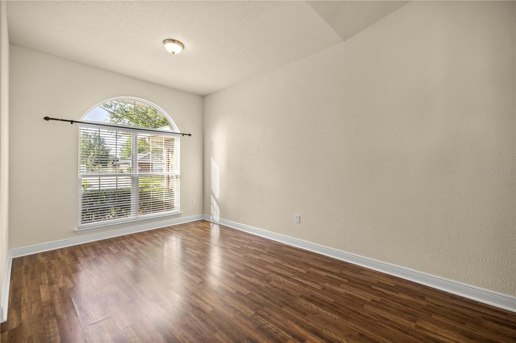 4441 Southwest 62nd Loop Ocala, FL 34474 - Photo 15 of 42 an empty room with wooden floor and windows