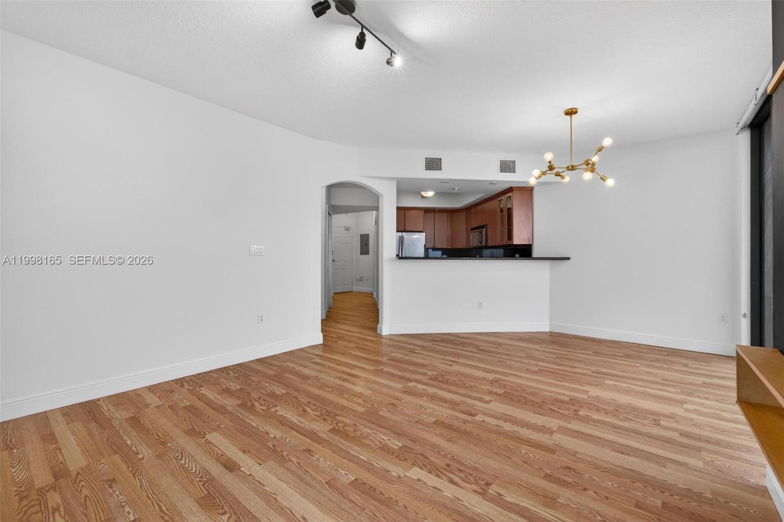2301 Southwest 27th Avenue, Unit 906 Miami, FL 33145 - Photo 16 of 38 a view of a room with a chandelier and wooden floor