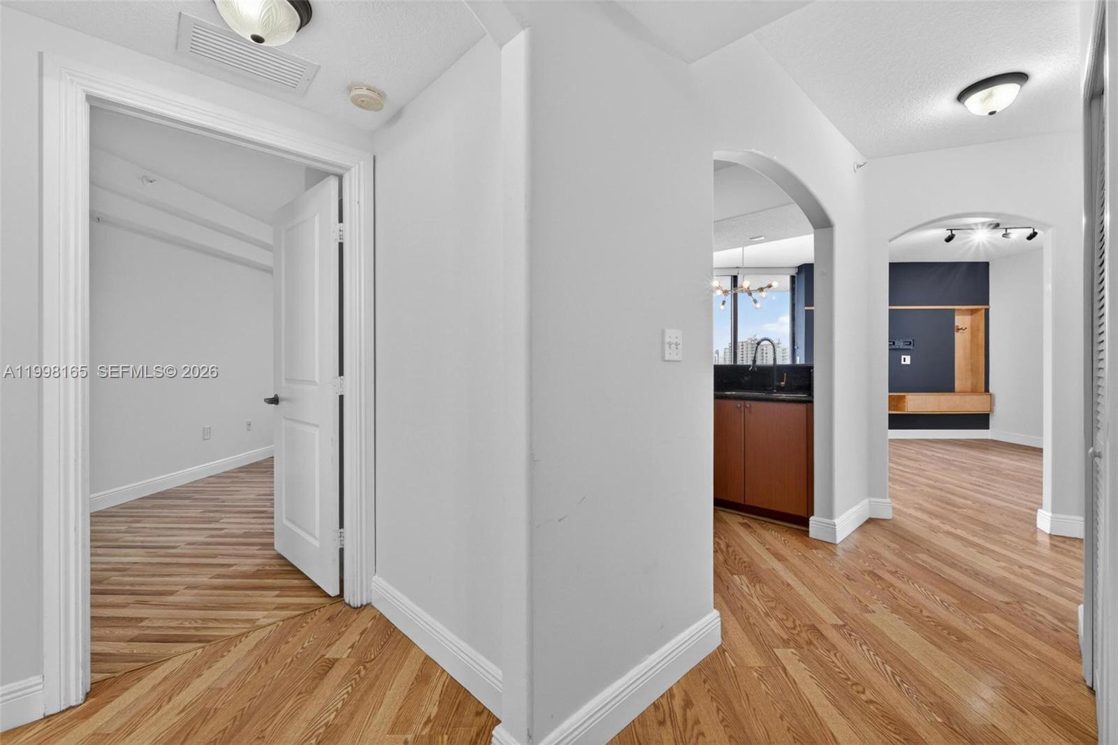 2301 Southwest 27th Avenue, Unit 906 Miami, FL 33145 - Photo 7 of 38 a view of a hallway with wooden floor and a bathroom