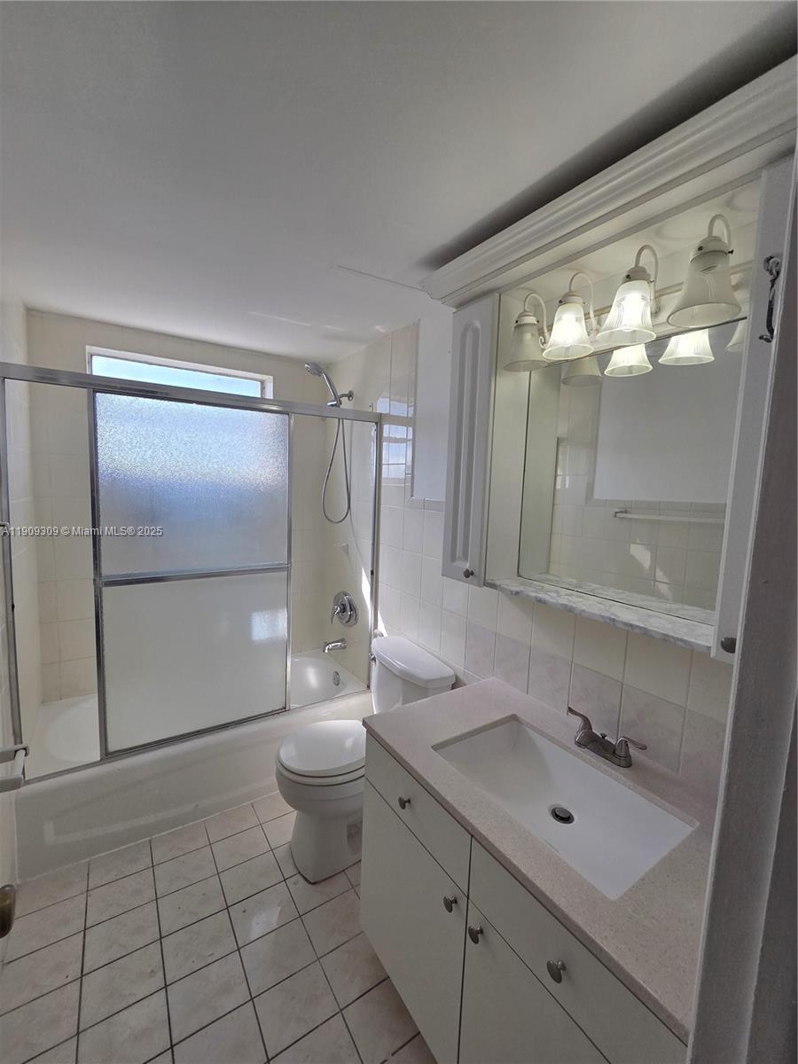 3640 Northwest 9th Street, Unit 407 Miami, FL 33125 - Photo 13 of 24 a bathroom with a double vanity sink mirror and toilet