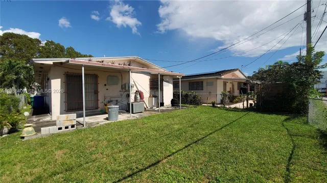 a view of a house with backyard sitting area and garden