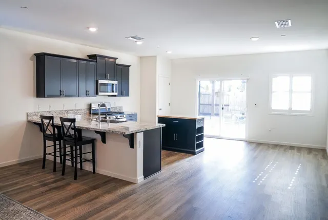 a kitchen with a sink cabinets and wooden floor
