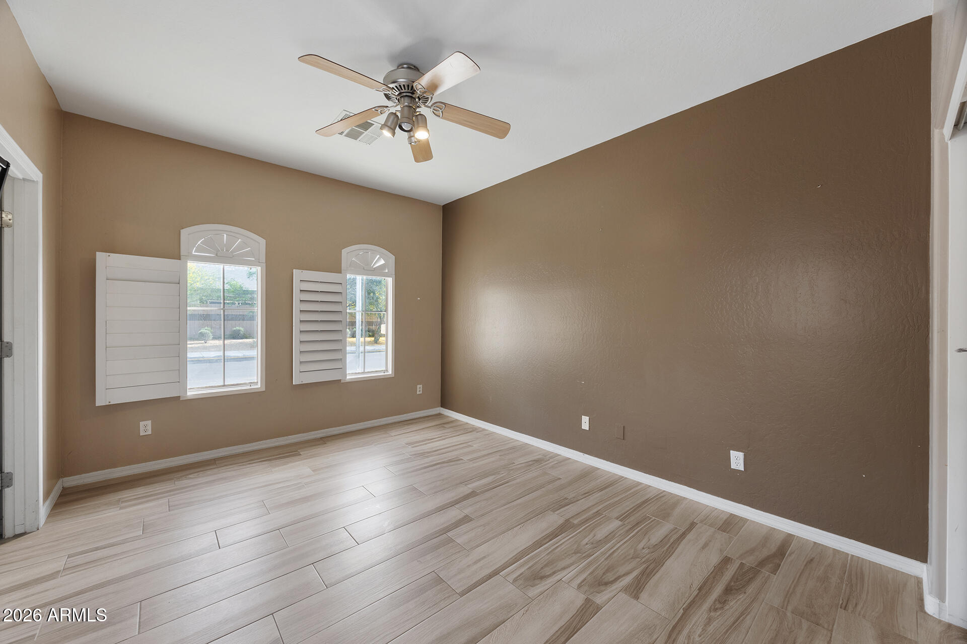 608 West Gary Way Phoenix, AZ 85041 - Photo 11 of 48 a view of an empty room with a window and wooden floor