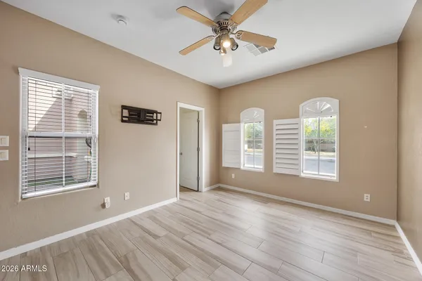 a view of an empty room with a window and wooden floor