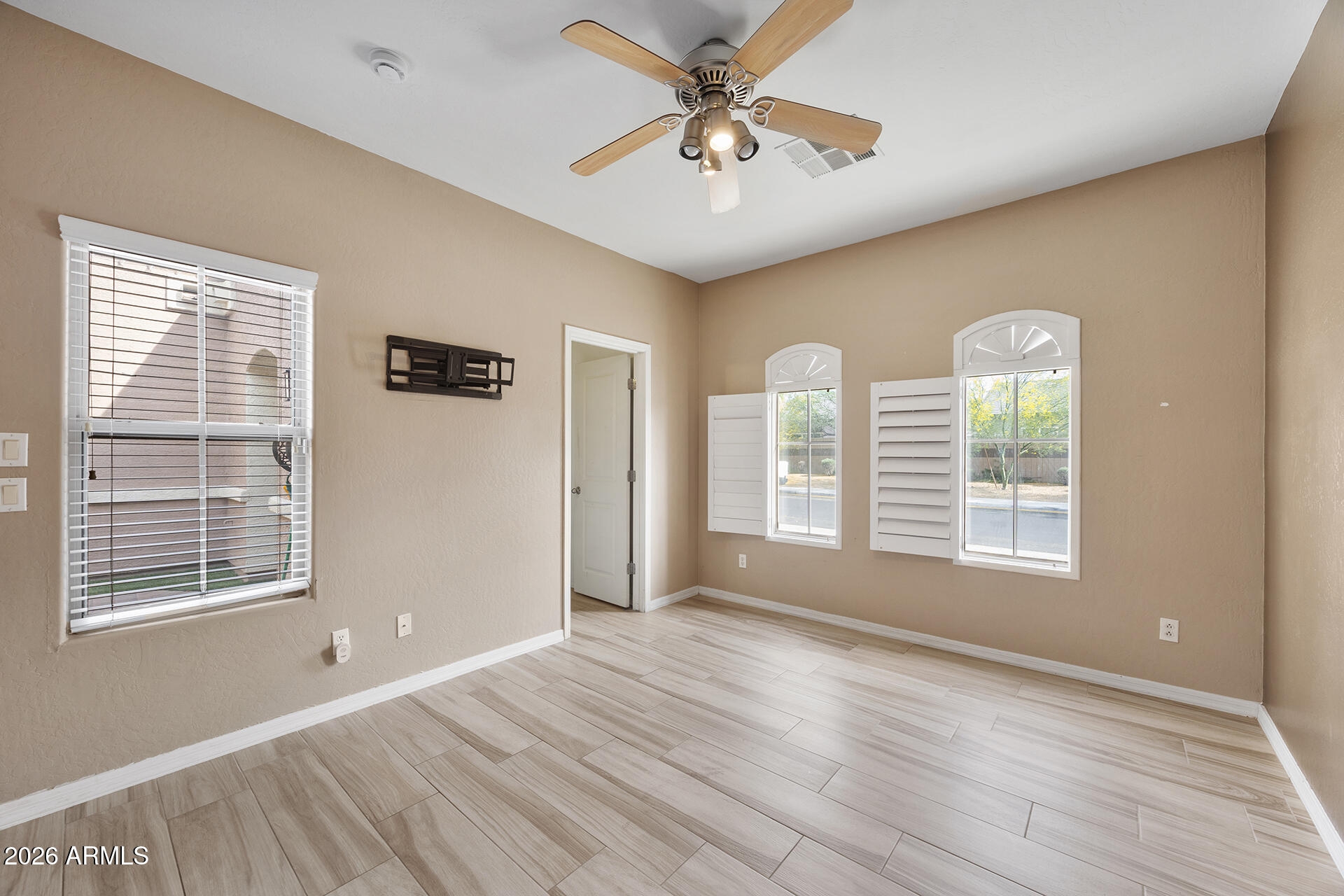 608 West Gary Way Phoenix, AZ 85041 - Photo 12 of 48 a view of an empty room with a window and wooden floor
