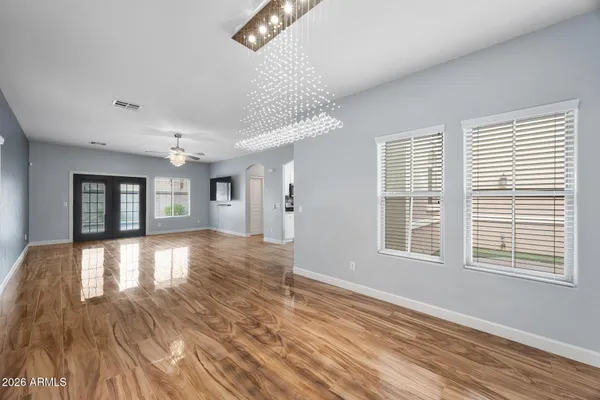 a view of empty room with wooden floor and fan