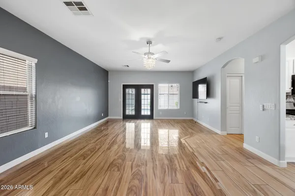 a view of an empty room with wooden floor and a window