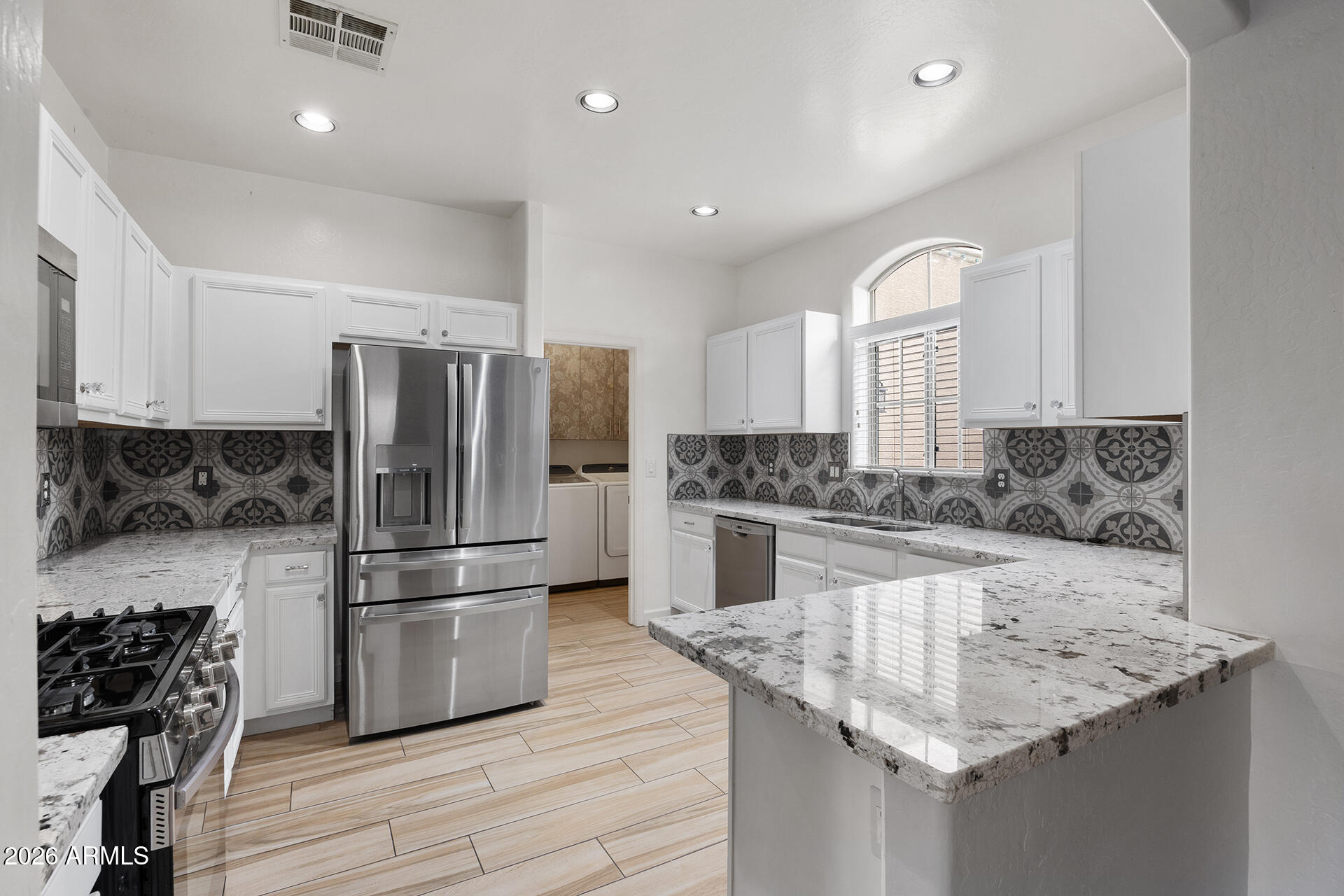 608 West Gary Way Phoenix, AZ 85041 - Photo 20 of 48 a kitchen with granite countertop a refrigerator oven a sink and white cabinets