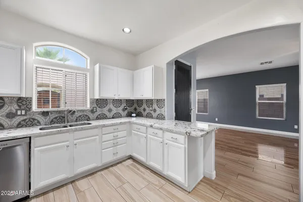 a kitchen with stainless steel appliances granite countertop a sink and cabinets with wooden floor