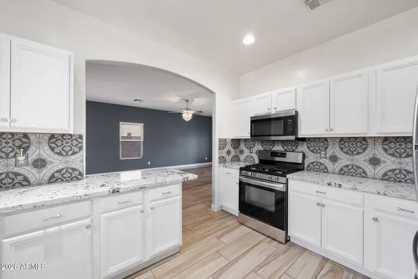 a kitchen with a sink stove top oven and cabinets
