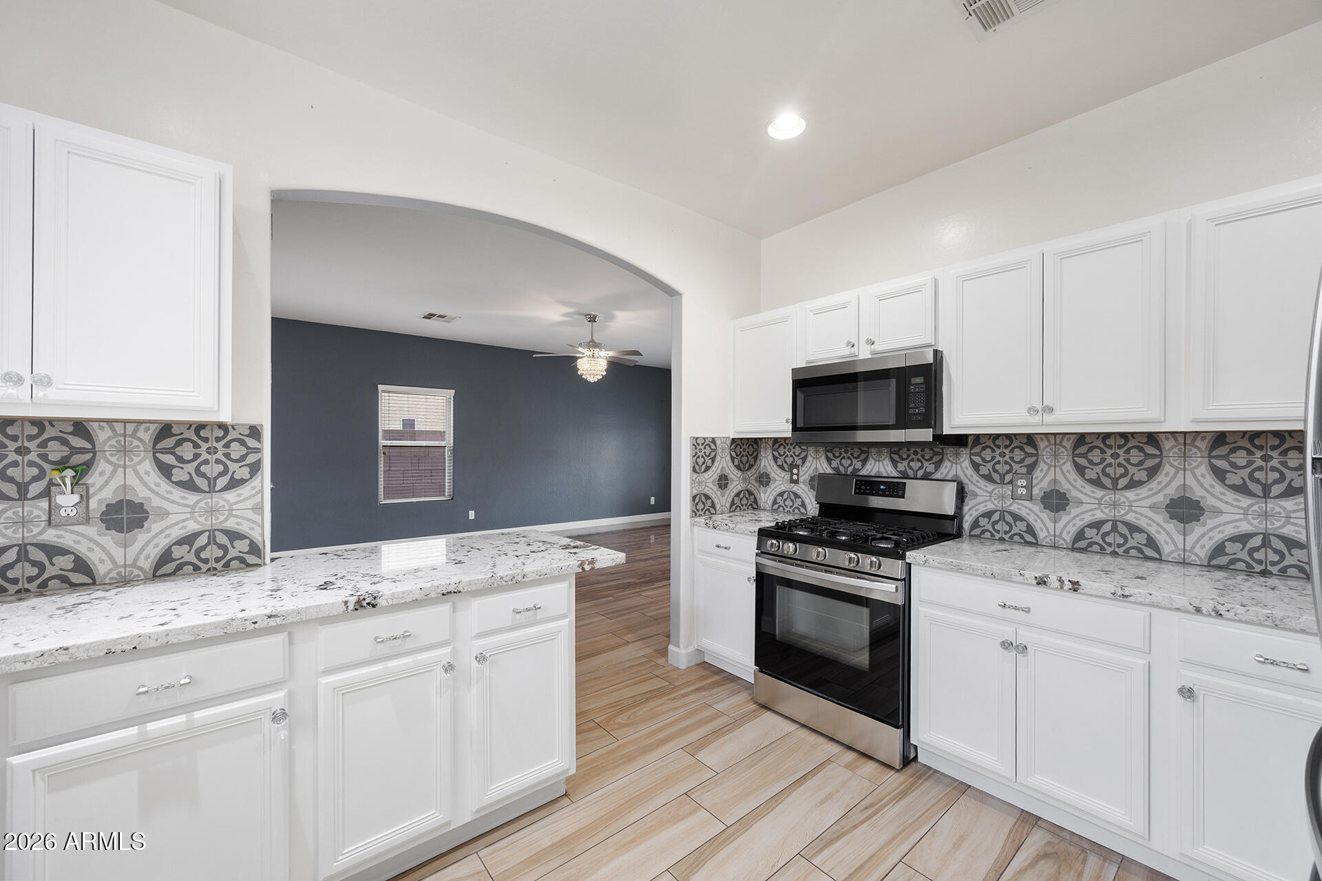 608 West Gary Way Phoenix, AZ 85041 - Photo 24 of 48 a kitchen with granite countertop white cabinets and stainless steel appliances