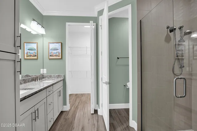 a bathroom with a granite countertop sink two mirror and shower