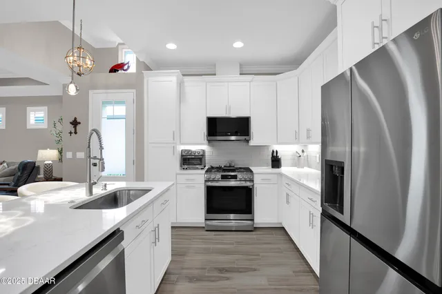 a kitchen with stainless steel appliances a refrigerator sink and stove