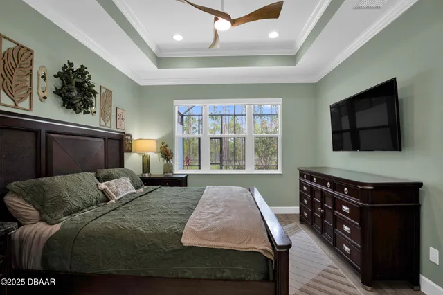 a bedroom with a bed and a flat tv screen on dresser