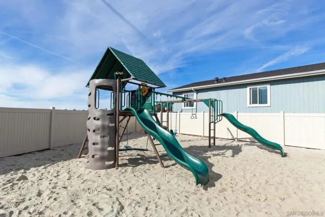 a house view with a wooden deck and a slide